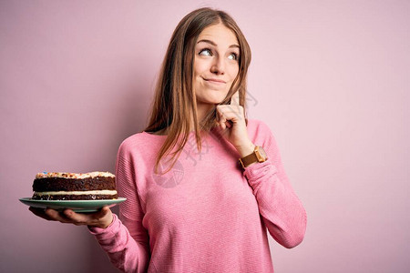 年轻漂亮的红发女人拿着生日蛋糕图片