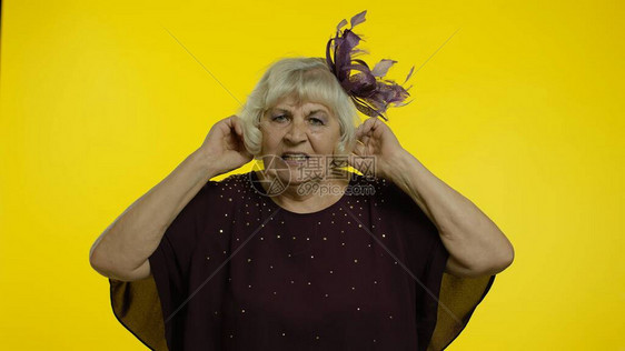 恼怒的资深老妇人捂着耳朵图片