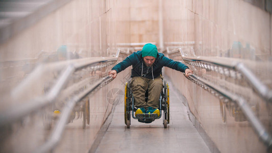 坐在轮椅上的残疾人在长的特殊坡道上站起图片
