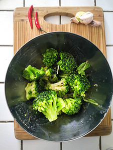 健康有机饮食素绿色西兰花在厨房白色瓷砖台面上的金属碗里图片