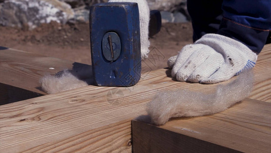 男木匠身穿制服和白手套在建造模板时锤击木梁的特写男工用大图片