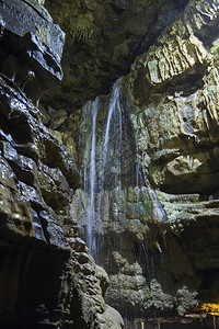 带瀑布的地下石灰岩洞穴中地质岩层的特写细节图片