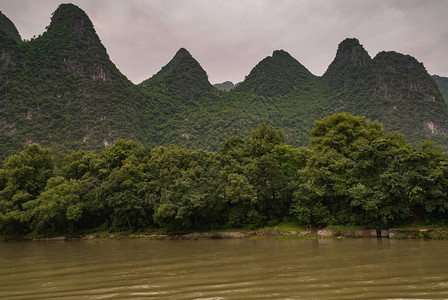 沿漓江一系列绿色覆盖的喀斯特山顶景观在银色的天空下图片