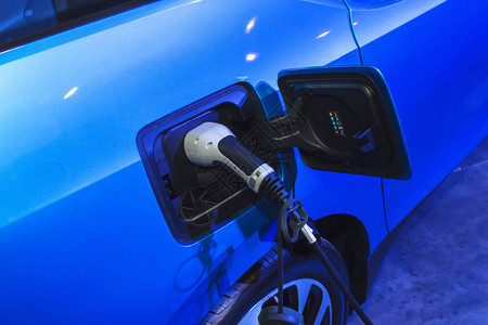 电动汽车或电动汽车在充电站插入电源线环保的图片