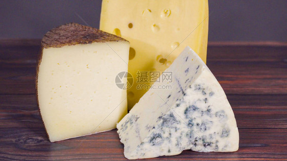 质朴的木质背景上的大块美味奶酪图片
