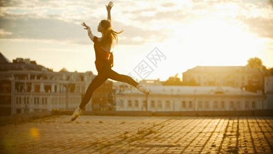 年轻优雅的女芭蕾舞女少跳舞到屋顶图片