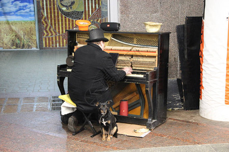 流浪汉在街上弹钢琴背景图片