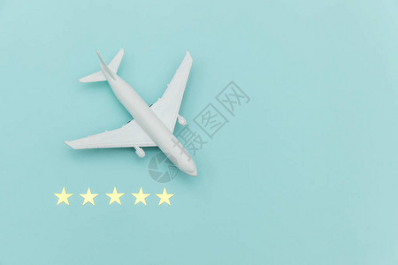 简单平躺设计微型玩具模型飞机和5星评级在蓝色柔和的彩色时尚背景乘飞机度假夏季周末海上冒险之旅程图片