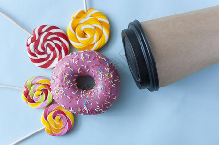 甜品创意布局带棒糖的甜点概念以及亮蓝纸背景顶视图复制空图片
