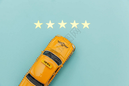 黄色玩具车出租车和5星评级隔离在蓝色背景出租车服务的智能手机应用图片