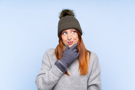 带着冬帽的俄罗斯年轻红发女红发女人与孤立的蓝色背景相比图片