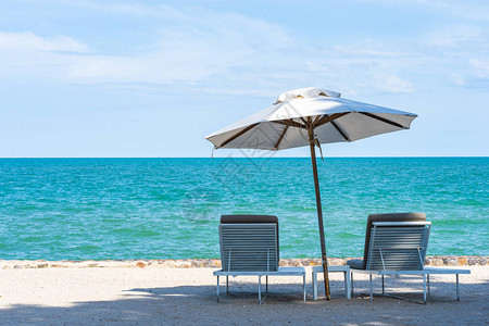 美丽的雨伞和沙滩海滨周围的椅子蓝色天空为旅行图片