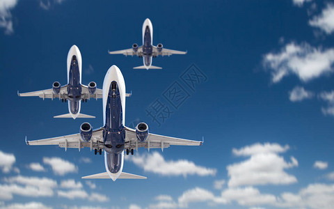 三架客机在蓝天飞行的底视图图片