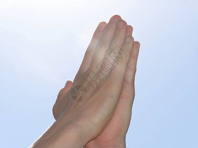 青少年的双手一起祈祷在光线下图片
