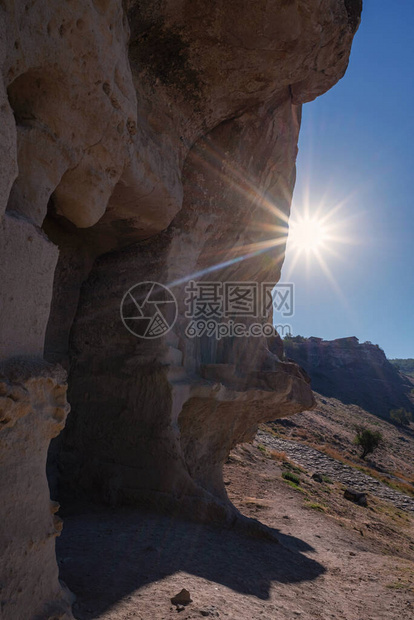 在山的一个洞的明亮的光芒四射的太阳图片