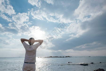 一个人在海滩上的日落背景年轻帅哥游客在海洋背景下享图片