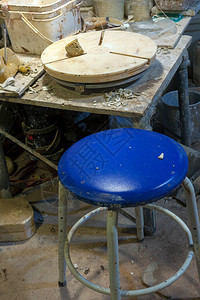 粘土工作室车间的陶轮带蓝色坐垫凳图片