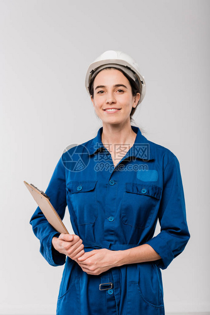 穿着蓝工作服和硬帽的年轻女机械技工快乐图片