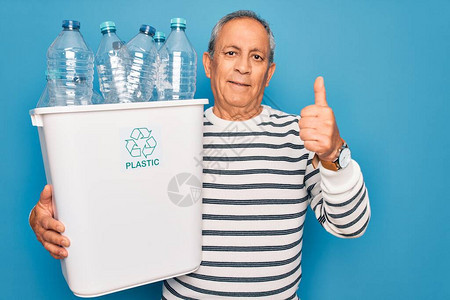 老人回收拿着带塑料瓶的垃圾桶图片