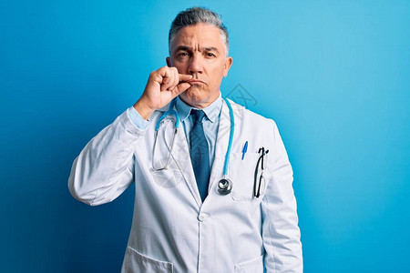 穿着大衣蓝色听诊器嘴唇和嘴唇的中年人长相英俊的灰色头发医生男子图片