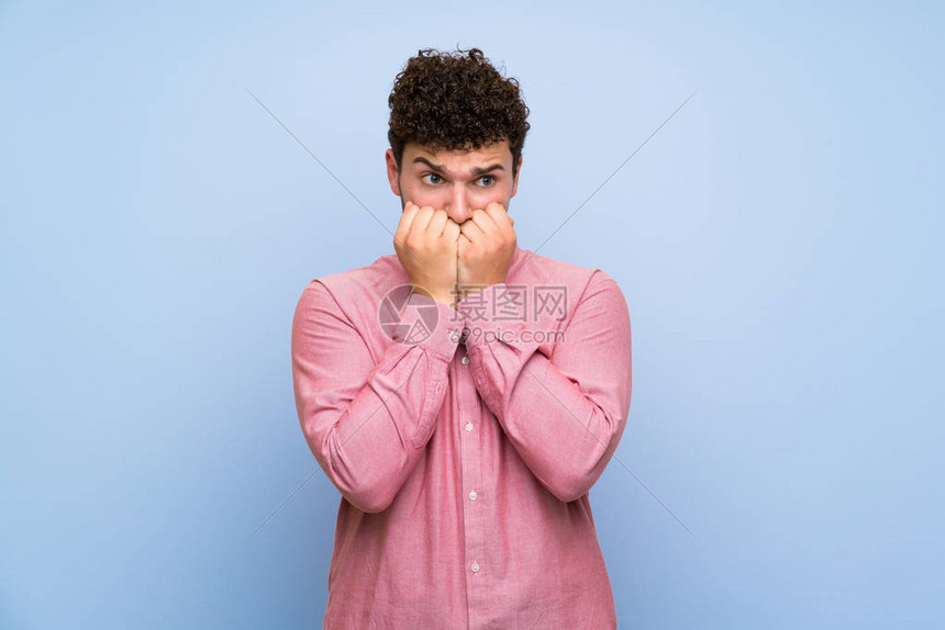 长卷发的男子在孤立的蓝墙上紧张不安高清图片下载-正版图片504433764-摄图网