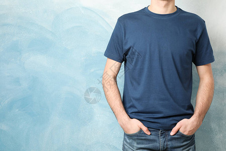 穿着空白蓝色T恤衫的男子以彩色背景文图片