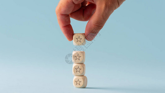 雄用概念图象把五只木制骰子堆叠成星形状的木制骰子在亮图片