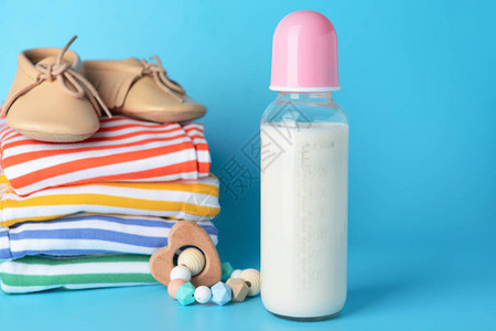 彩色背景衣服的婴儿牛奶瓶图片