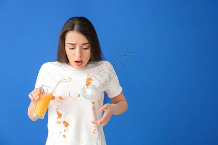 穿着脏衣服的年轻女子在彩色背景上喝果汁图片