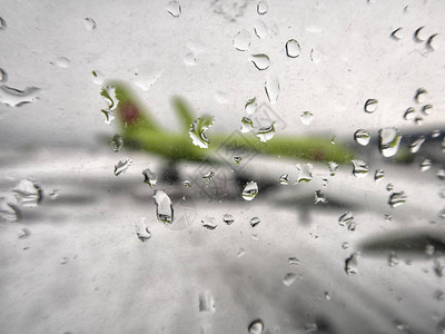 机场跑道的雨天侧玻璃窗落下的雨滴世界各地情绪旅行的概念图片