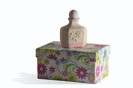 纸瓶上的香水陶瓷瓶装饰着白色背景上孤立的白色花朵图片