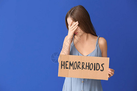 年轻女持有纸和文字的HEMORRHOI图片