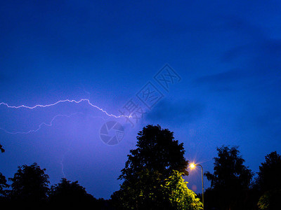 闪电孤树灯杆的夜景图片