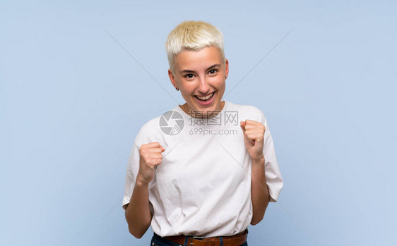 蓝墙上白短发的少女欢庆胜利获胜图片
