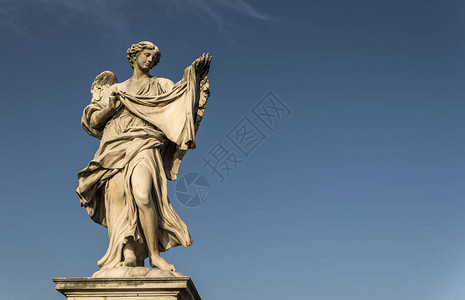 一个巨大的天使的石头雕像与深蓝的图片