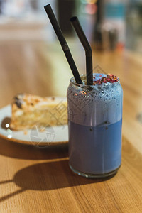 在咖啡店喝蓝色火柴的饮料健康而适当的昂贵茶木制桌上有一块蛋糕图片