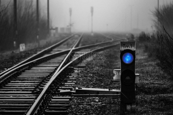 铁路交界处消失在雾中的蓝光铁路信号图片