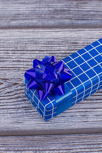 有白色格子的蓝色礼物盒蓝色纸板礼品盒与仿古木制背景上的蝴蝶结节图片
