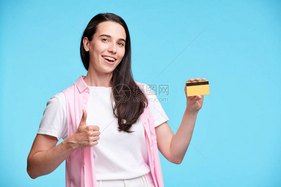 快乐的年轻女购物狂单独展示大拇指手势图片
