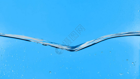 蓝色背景上带有水滴的波浪状透明水背景图片