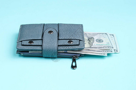 蓝色背景的皮衣钱包和一百元钞票图片