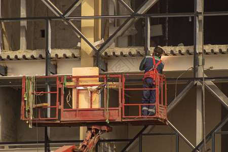 利用电焊接汽车电梯起吊工人远升机维修大楼外墙图片