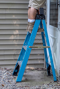 一名工人站在梯子上他在屋图片