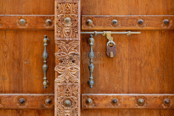 阿曼AlMudairib老城棕色木制门雕刻和金图片