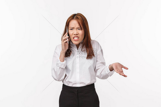 不满意的愤怒亚洲女人在电话里说话图片