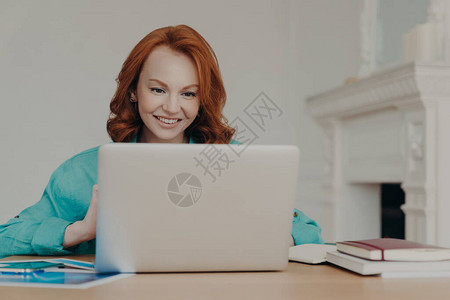 专注快乐的红发成功女商人做研究图片