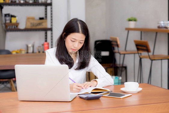 商业女在笔记本上用笔记本电脑写字图片