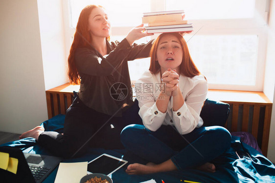 重的学习理念一个学生把一个拿着很多书的年轻女人放在她的头上第二次祈图片