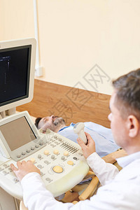 超声医师在检查患者时查看超声机屏幕并图片
