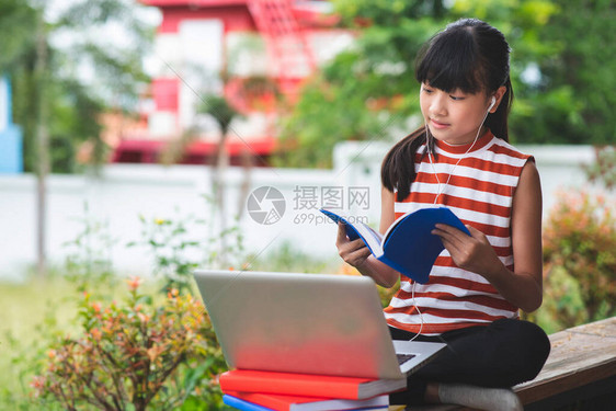 亚洲的小学生在离家很远的地方坐学在线教育概念图片